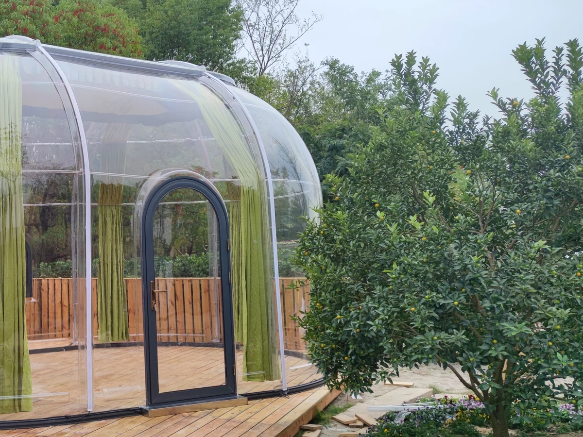Extended oval Celenest dome on a timber deck beside a lawn