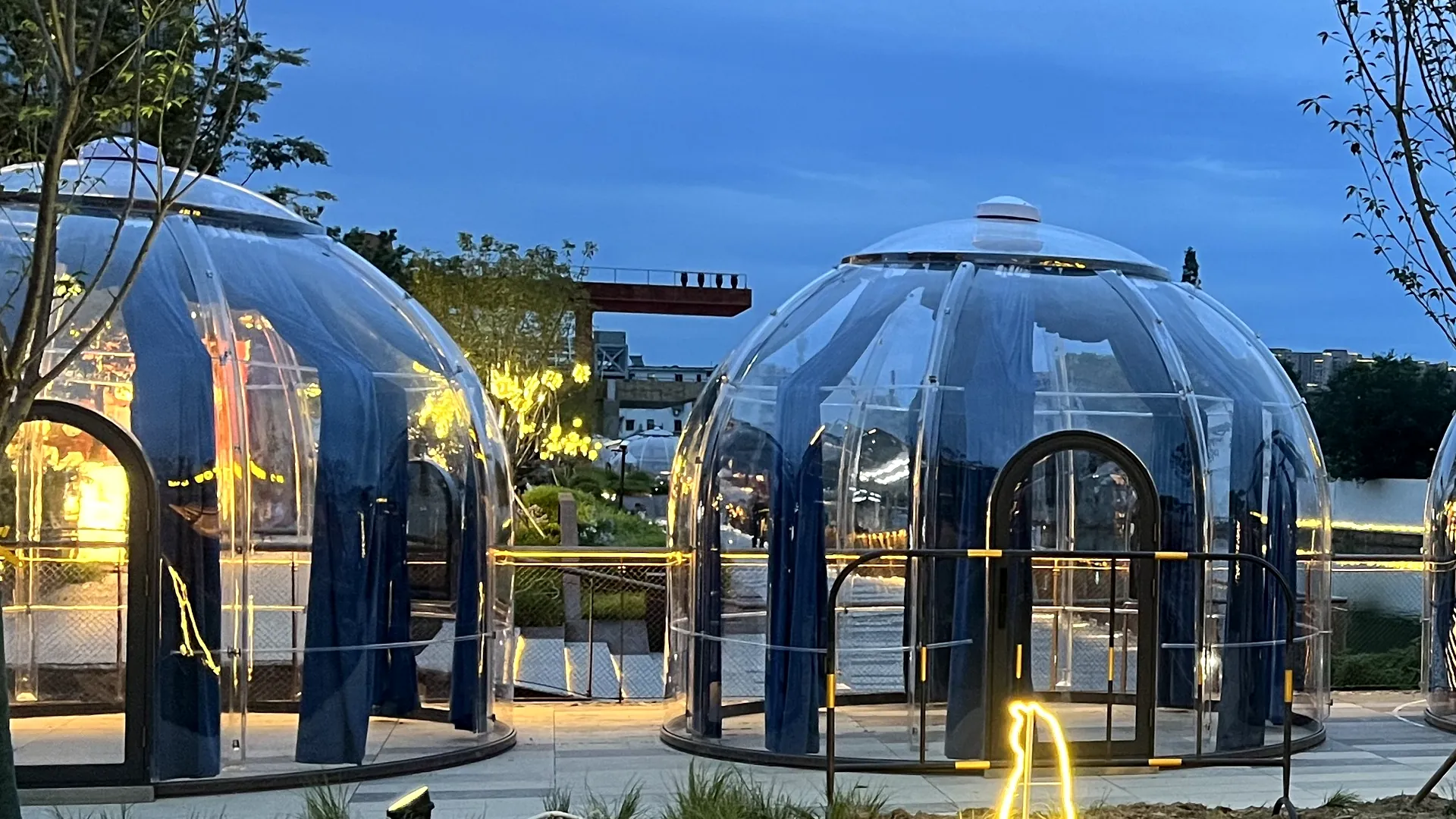 Two transparent Celenest domes lit from within at blue hour