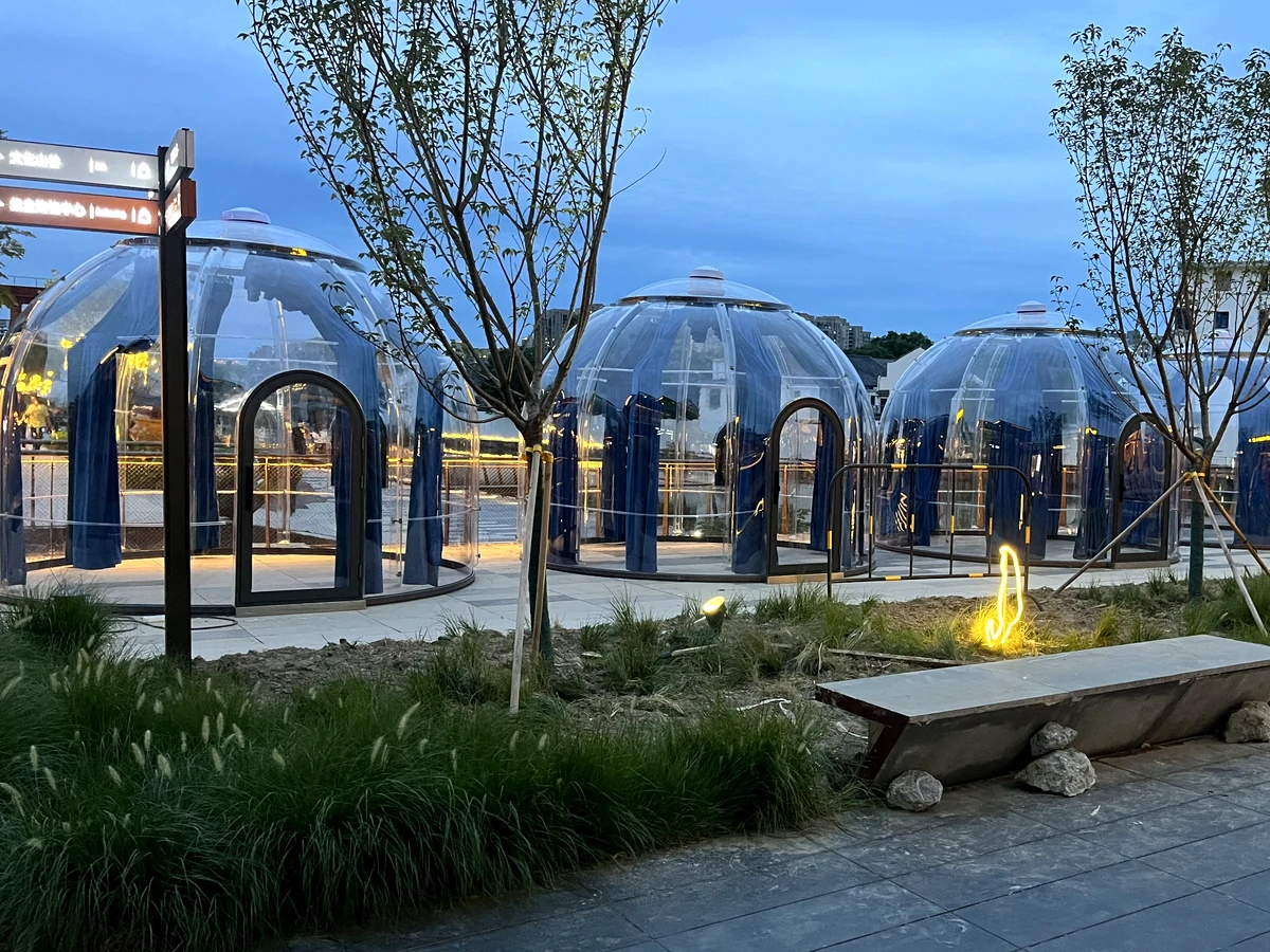 Celenest domes at blue hour beside an outdoor fire feature
