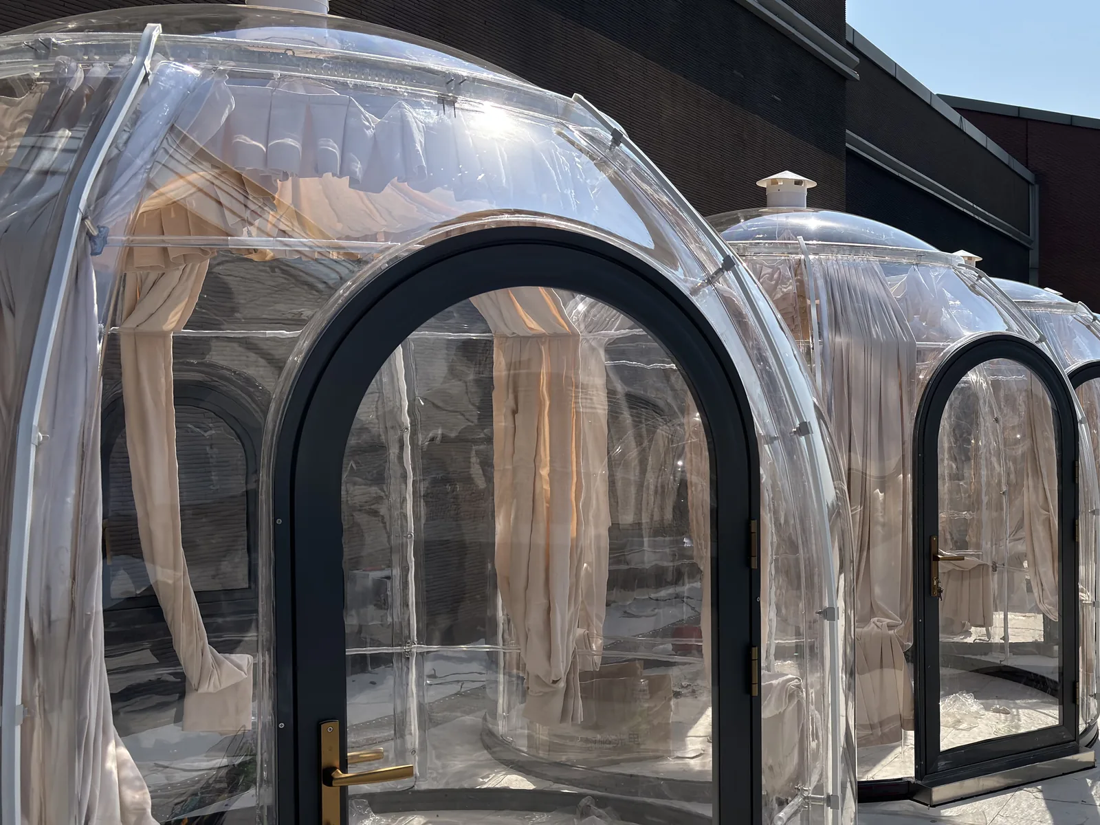 Close view of a rigid clear polycarbonate shell with an aluminium arch door